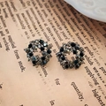 Dettaglio di orecchini circolari in stile vintage con strass scuri su carta antica - Perno in Argento - Orecchini a Bottone a Cerchio con Strass Neri