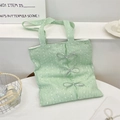 Detalle del bolso tote de encaje verde menta con tres lazos plateados y bordados de lentejuelas - Verde