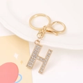 Close-up of golden letter H keychain with sparkling rhinestones and lobster clasp - Letter H