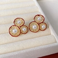 Detailed macro view of vintage red floral stud earrings with round pearls and gold trim - Zircon Pearl Oval Hollow Style