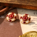 Detalle de pendientes vintage de esmalte rojo con acabado dorado y perlas - Pendientes de esmalte redondo rojo