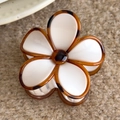 Detail shot of white flower claw clip with amber edges on a textured brown blanket - White Flower Large