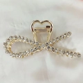 Detail of elegant gold metal hair claw clip featuring a rhinestone bow design for styling - Bowknot Style (F-002)