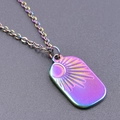 Macro detail of rainbow stainless steel pendant with solar sunburst engraving - Rainbow Color Necklace