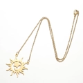 Dettaglio di una collana con ciondolo a sole dorato con incisione cava su catena sottile - Sole Luna Stella Oro