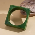 Detailed view of dark green marble-textured acrylic square bangle on raw stone - Green