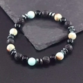 Detailed view of 8mm natural lava rock and tiger eye beaded bracelet on stone surface - Lava + Glossy Stone + Shoushan Stone