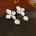Dettaglio di orecchini a fiore in metallo spazzolato con perle d'acqua dolce bianche - Argento (Perla Sintetica)