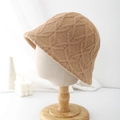 Stylish camel knit bucket hat with textured floral pattern on a professional display stand - Camel