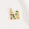 Detailed macro view of gold letter M pendant with colorful zircon stones inlay - Letter M