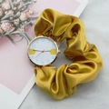 Close-up of elegant gold watch with yellow silk ribbon band and white arabic dial - Yellow