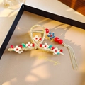 Elegant gold metal flower hair claw with white petals, red beads, and long tassels - Lily of the Valley Red Fruit Tassel Claw