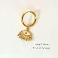 Macro shot of gold hoop earring with white enamel evil eye charm and clear zircon stones - Pave Zircon Eye