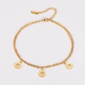 Detail der doppelstöckigen goldfarbenen Edelstahl-Fußkette mit drei Blumenanhängern und Karabiner - Gold