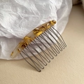 Close-up of amber tortoiseshell cellulose hair comb with polished silver metal teeth - Yellow Amber Pattern