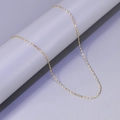 Close-up of golden wavy twisted chain necklace on a minimalist grey pedestal - L22-Starry Chain / Gold