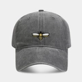 Close-up of a vintage washed cotton baseball cap with detailed yellow bee embroidery - Gray