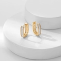 Macro detail of gold U-shaped hoop earrings with rectangular zircon inlay and hollow grid - White Zirconia