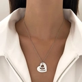 Close-up of heart-shaped triple pendant necklace layered on a white shirt collar - Triple Layered Heart Style (10 Stainless Steel M-697)