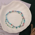 Colorful handmade seed bead bracelets in a white shell dish on a dark green background - Style 13-Double Multicolor