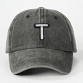 Close-up of the white embroidered letter T on a charcoal washed cotton baseball cap - Letter T