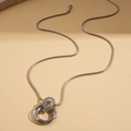 Dettaglio catena serpente argento con pendenti circolari intrecciati e finitura lucida - Argento