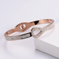Bracciale rigido in oro rosa con gocce d'acqua e cristalli luminosi vista angolata - Oro rosa