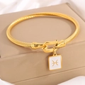 Vergoldetes gedrehtes Kabelarmband mit weißem Emaille-Fische-Anhänger und Hufeisenschließe - Gold Fische