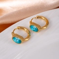 Elegant gold hoop earrings with oval sky blue crystals on a premium silk background - Oval Zircon / Blue