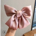 Elegant large pink satin bow hair clip with silky texture held against a neutral background - Pink Satin Large Bow