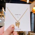 Elegant gold bow pendant necklace with sparkling cubic zirconia on a white card - Bow / Gold
