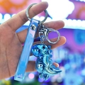 Blue chrome dinosaur keychain with translucent strap held in hand under neon light - Wrist Strap + Dinosaur / Blue