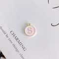 Detailed view of round pink enamel letter S pendant for DIY necklace accessories - Letter S