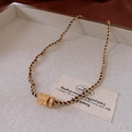 Dettaglio del ciondolo cilindro dorato con quadrifoglio in zircone su laccio nero - Collana - Oro (Grande)