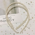 Close-up of two elegant white pearl headbands in different sizes on a starry mesh background - Style E Large and Small Pearl Headband 2-Piece Set