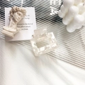 Square marble texture acetate hair claw in off-white finish on a glass tray - Shell White