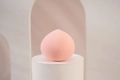 Pink teardrop makeup sponge on white pedestal with soft geometric lighting and shadows - Soft Pink Waterdrop