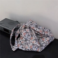 Dettaglio ravvicinato di una borsa in cotone con motivi floreali vintage blu e arancio - Nero Rosso Vintage