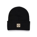 Close-up of a black knitted beanie featuring a beige square patch with a smiley face icon - Black