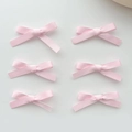 Détail montrant un lot de six barrettes à nœuds en ruban de satin rose bien alignées - Rose (Lot de 6)