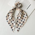 Detailed texture of cream bow scrunchie with orange grid and compass star patterns - White & Orange Satin Ribbon