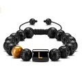 Macro shot of 10mm lava rock bracelet with tiger eye stone and golden letter L bead - Letter-L