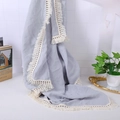 Detail of grey cotton muslin baby blanket featuring decorative white tassel edges - Grey Blue