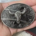 Macro shot of silver belt buckle with bull skull relief and western floral engraving - Western Bull Head