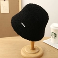 Primer plano de sombrero de pescador de felpa negra con placa de metal en soporte de madera - Negro