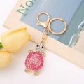 Golden turtle keychain with pink gradient rhinestones and opal details on white table - Turtle 12 (Pink Gradient)
