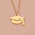 Detailed macro view of the gold graduation cap pendant on a delicate link chain necklace - Gold
