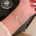 Elegant gold flower bracelet with zircon leaves and cat's eye stone worn on wrist - S751 Gold