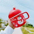 Red Santa Claus ceramic mug with snowman design and lid held in hand outdoors - Snowman