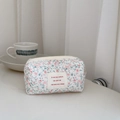 Close-up of French floral quilted cotton pouch with elegant logo and zipper detail - White with Pink Floral and Green Leaves
